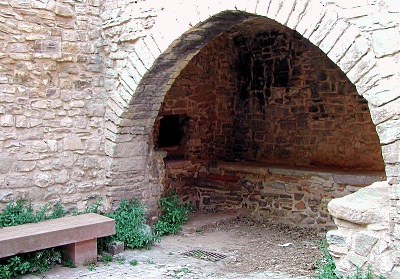 Open stone arch leads to roofed baking space